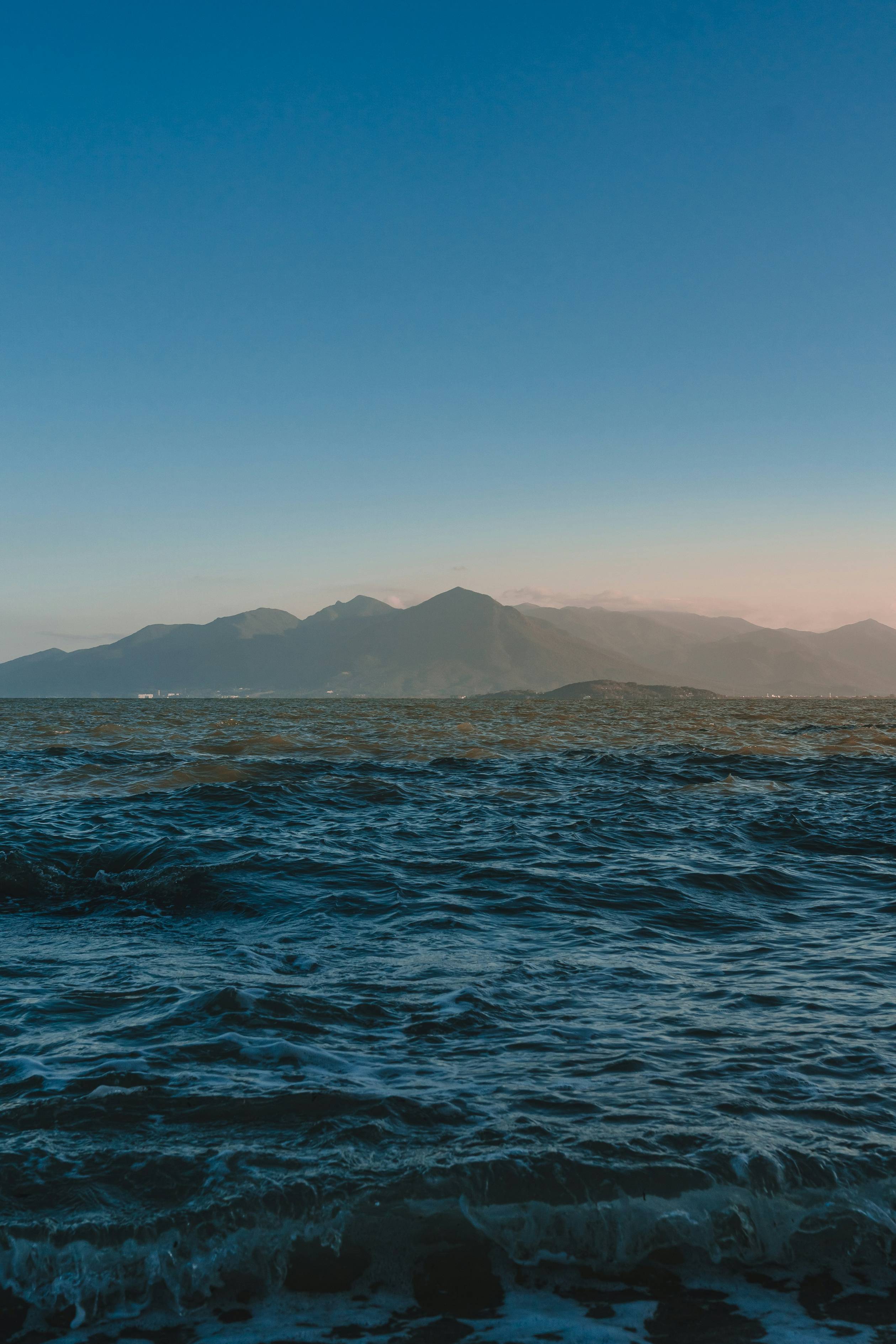 a body of water with mountains in the background
