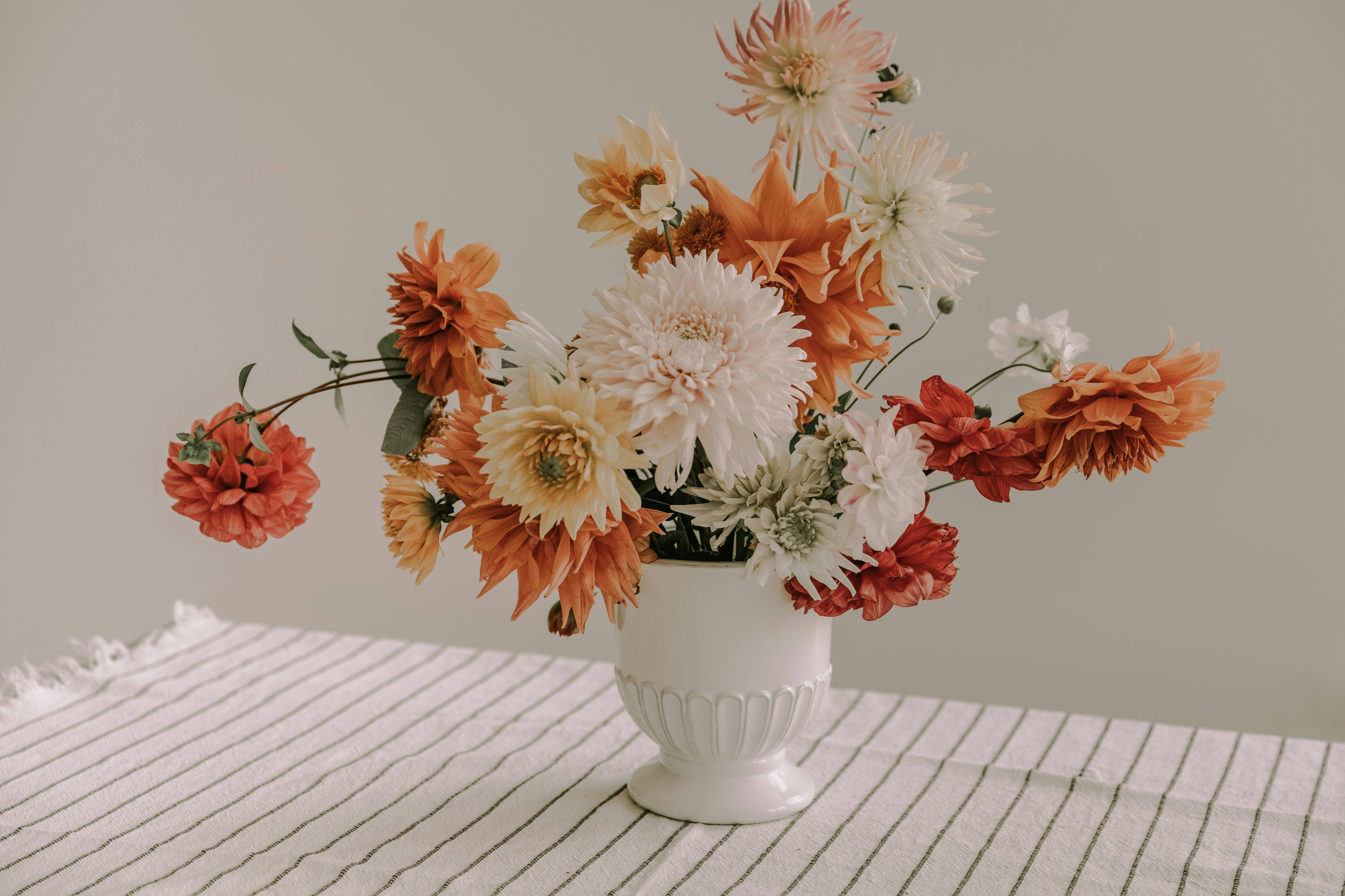 A vase filled with lots of flowers on top of a table